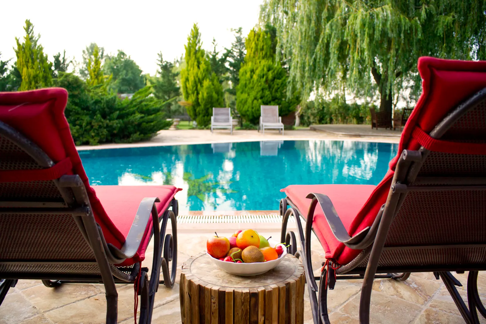Backyard fire pit with lounge seating overlooking a Pilot Point, TX pool